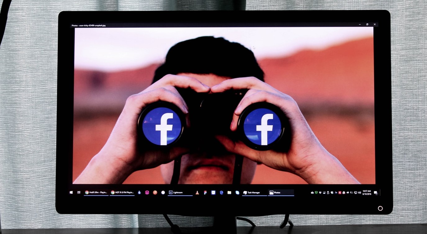 una persona mirando por unos binoculares logos de Facebook